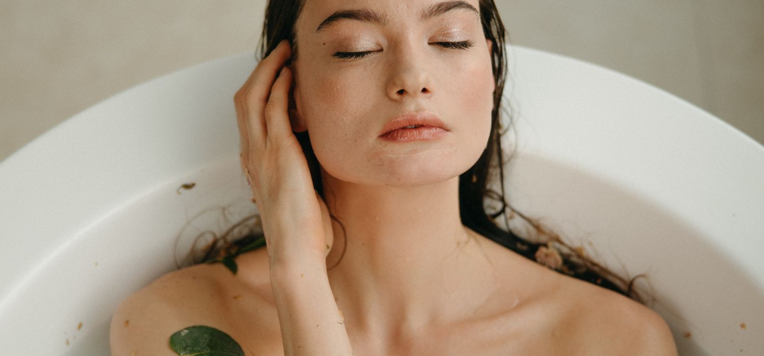 close-up of a woman in a hot spring bath at home as part of her skincare self-care routine