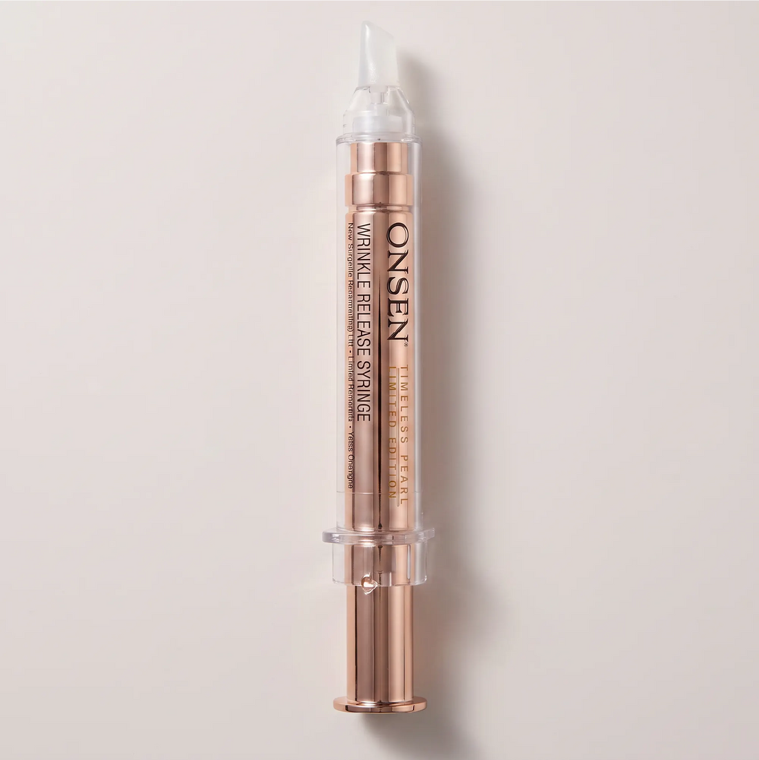 Onsen Secret Wrinkle Release Syringe Timeless Pearl, rose‑gold skincare applicator with transparent tip and clear cap for targeted wrinkle care.