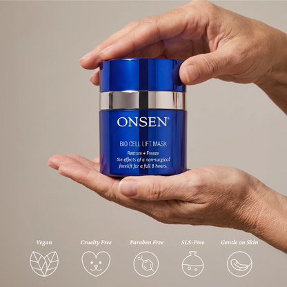 Onsen Secret Bio Cell Lift Mask, blue cosmetic container with silver band held in hands, highlighting vegan, cruelty free, paraben free, SLS free, and gentle on skin features.